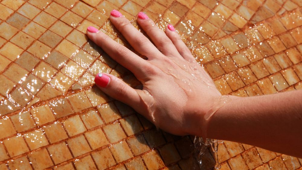 水の流れているタイルに手をつけている