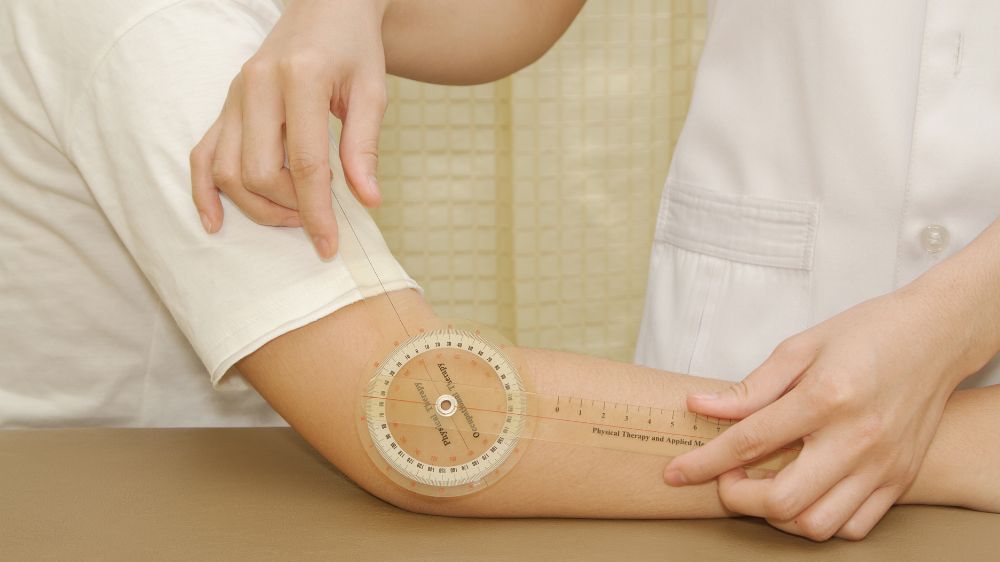 角度計で肘の関節可動域を計測している様子