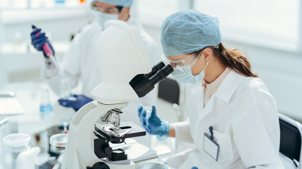 研究室で顕微鏡を覗き込む研究員
