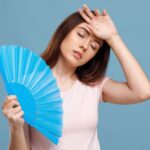 暑そうにしながら扇子で仰ぐ外国人女性