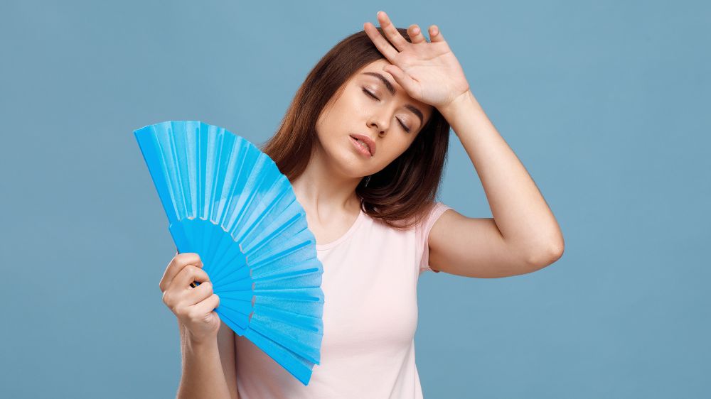 暑そうにしながら扇子で仰ぐ外国人女性