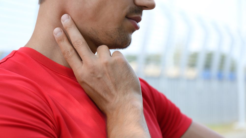 首の頸動脈で脈拍を測る男性