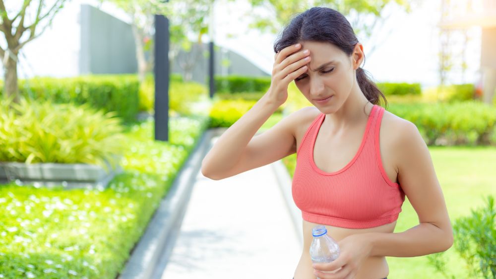熱中症で頭痛が出ている外国人女性