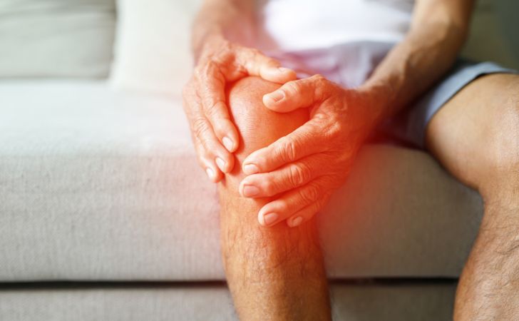 膝が痛くておさえている男性