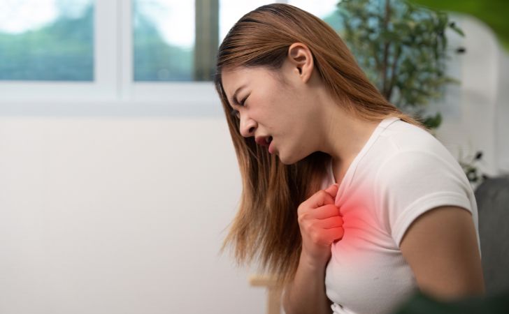 胸部痛で胸をおさえる女性