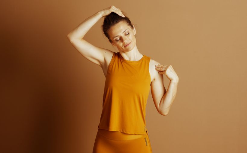 首のセルフストレッチをしている女性