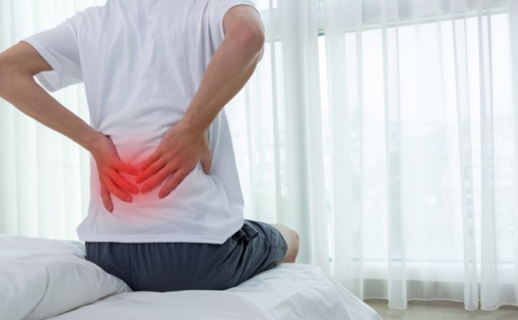 ぎっくり腰で腰をおさえる男性