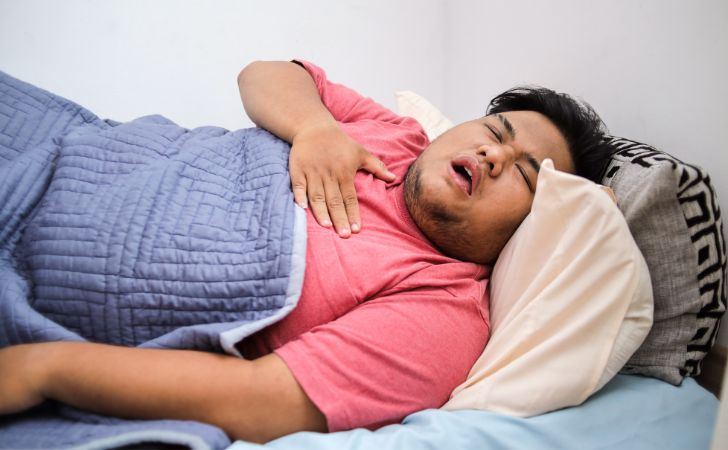 胸の痛みで寝込み、苦しんでいる男性