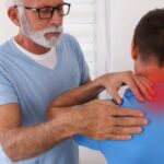 首の痛みを訴える患者と場所を確認する整体師