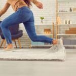 カーペットに足を引っかけてつまずく女性