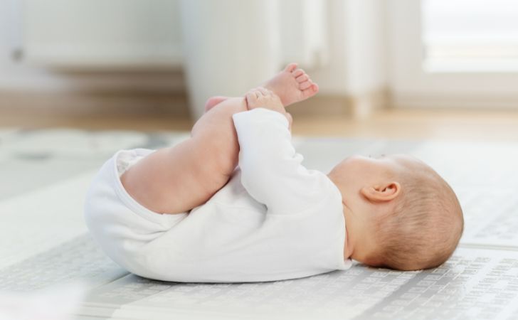 あお向けで自分の足を掴んでいる赤ちゃん