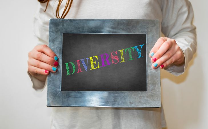 多様性（diversity）と書かれた黒板を持つ女性